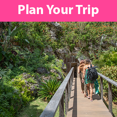 Tourists going to Grotto Bay with a text above "Plan Your Trip"